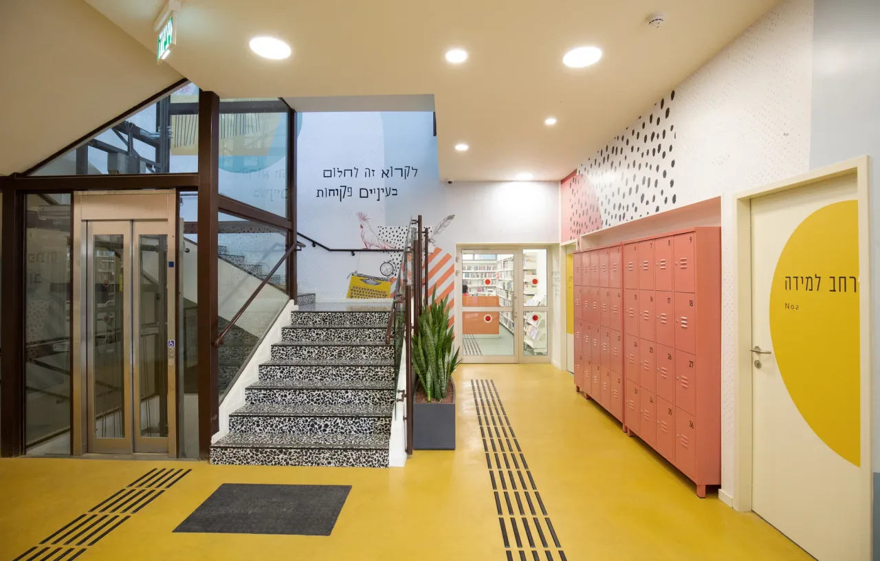 חלל הספרייה העירונית באשדוד עם גרפיקה צבעונית, שילוט ומדרגות
