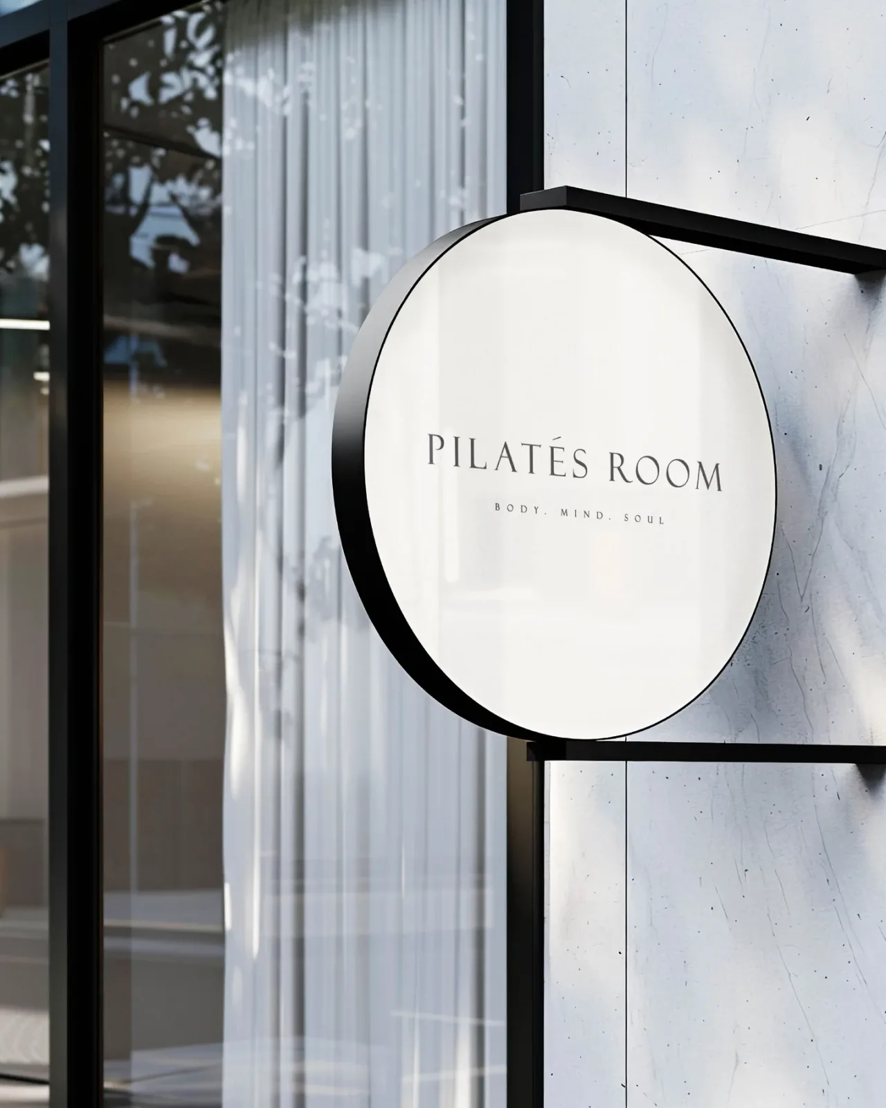 שלט עגול של Pilates Room בחזית זכוכית